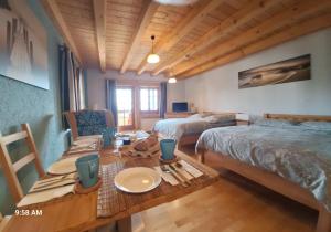 una camera con due letti e un tavolo in legno di Villa Grenzenlos a Löffingen