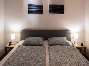 a bedroom with a bed with two pillows and two lamps at Chic Asboth City Center Loft - Perfect Location in Budapest +11 photos