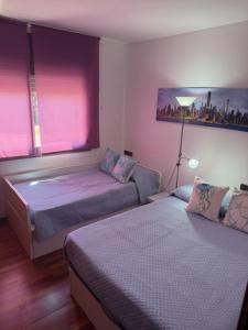 two beds in a bedroom with pink lights on the window at Vacaciones Cambrils sol Park in Cambrils +32 photos