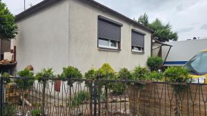una casa con una recinzione con delle piante davanti di Domowe Zacisze a Szamotuły