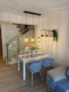 a dining room with a white table and chairs at Vacaciones Cambrils sol Park in Cambrils