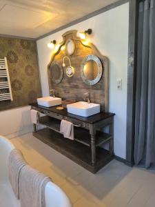 Gîte en Provence في كافايو: حمام به مغسلتين ومرآة