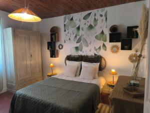 Gîte en Provence في كافايو: غرفة نوم بسرير وجدار مع اوراق الشجر