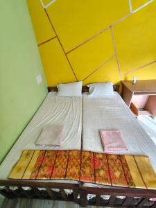 a large bed in a room with a yellow wall at IDANN Homestay in Cochin