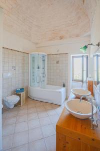 un bagno con due lavandini, una vasca e un WC di Casa del Sud a Ostuni