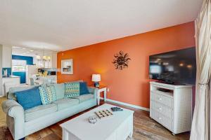 a living room with a couch and a tv at The Beach Escape in Clearwater Beach