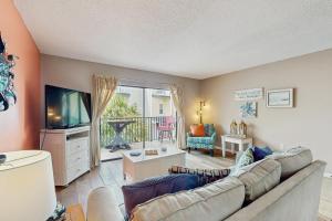 a living room with a couch and a television at The Beach Escape in Clearwater Beach