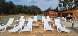 GrabceZacisze obok Suntago Park domki 2,3,6 osobowe的一组白色的椅子、一张桌子和一个男人