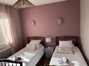 two beds in a bedroom with dolls on them at Gîte familial en Sologne : jardin, équipements enfants, vélos, proche Châteaux de la Loire - FR-1-491-348 in Dhuizon