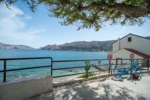 Una casa con una bicicleta estacionada al lado del agua. en Apartments Mihael, en Baška