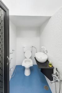 a bathroom with a white toilet and a sink at Alfiya Residency - Green Park in Indore