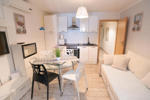 a kitchen and living room with a table and chairs at Apartments Mihael in Baška