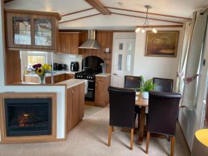 a kitchen with a fireplace and a table and chairs at Number 28 Dornoch Firth Caravan Park in Dornoch