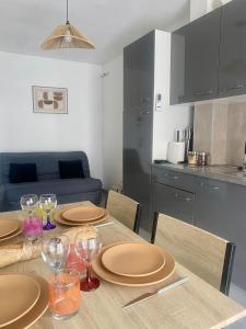 un tavolo da pranzo con piatti e bicchieri da vino di Appartement climatisé côté port a Canet-en-Roussillon