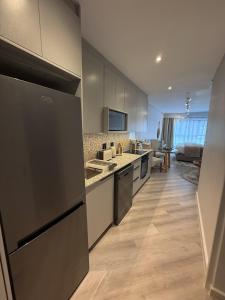 a kitchen with stainless steel appliances and a living room at Platform 132 - 2 On Tabak with onsite Parking in Paarl