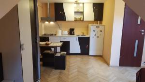 a kitchen with a table and a white refrigerator at Studio Piata Sfatului - Brasov in Braşov