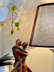 une statue de deux personnes assises sur une table à côté d'une lampe dans l'établissement Cebu Cozy Stylish 1 BR Escape, à Cebu 24 autres photos