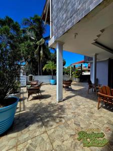 a patio with a bunch of chairs and tables at Porto De Galinhas Pousada Raízes Do Porto in Porto De Galinhas