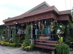 a restaurant with plants in the front of it at Mgrand Hotel in Ban Non Sombun