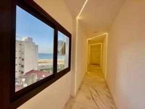 a hallway with a window with a view of the ocean at Bright Corniche Escape - 2 BR Urban Flat in Tangier