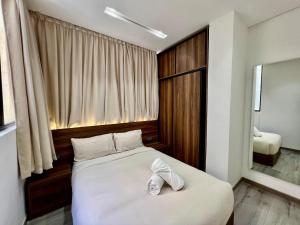 a bedroom with a large white bed with towels on it at Bright Corniche Escape - 2 BR Urban Flat in Tangier