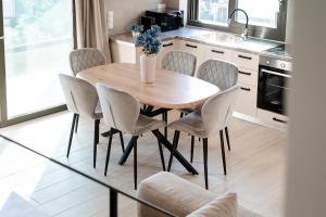 a kitchen with a wooden table and chairs at Solmare Loft Suite in Nikiana