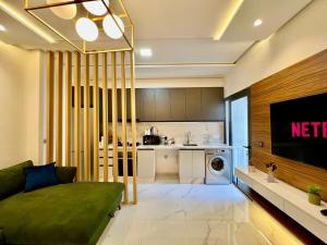 a living room with a couch and a kitchen at Bright Corniche Escape - 2 BR Urban Flat in Tangier