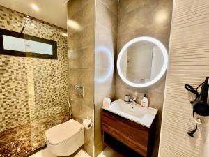 a bathroom with a sink and a toilet and a mirror at Bright Corniche Escape - 2 BR Urban Flat in Tangier +18 photos