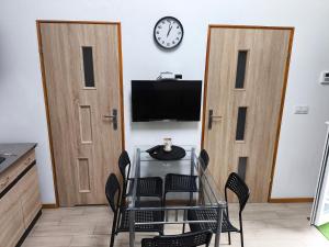 a dining room with two doors and a table with chairs at Olszynowe Wzgórze in Sianozety