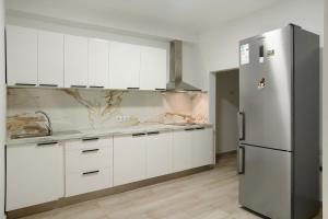 a kitchen with white cabinets and a refrigerator at Apartamento Casa Italia in Vecindario +12 photos