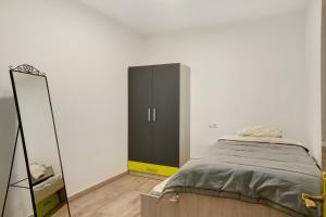 a bedroom with a black cabinet and a mirror at Apartamento Casa Italia in Vecindario