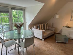 a living room with a glass table and a couch at Eastside am Kurpark in Timmendorfer Strand