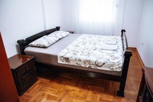 a bedroom with a bed and a wooden floor at Central in Nikšić