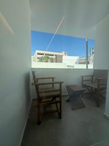 two chairs and a table in a room with a window at Tuck Inn in Larnaca