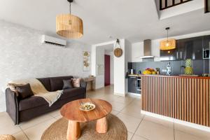 圣马丁岛MANGO ! Vue lagon et Sunset Appart duplex 6à7 p tout neuf的带沙发和桌子的客厅