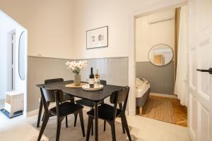 a dining room with a black table and chairs at Harmony House Apartment in Budapest +15 photos