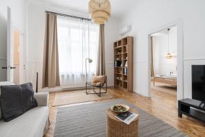 a white living room with a couch and a table at Harmony House Apartment in Budapest