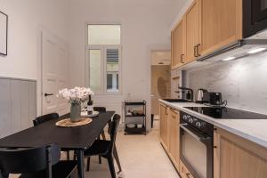 a kitchen with a table with chairs and a counter top at Harmony House Apartment in Budapest