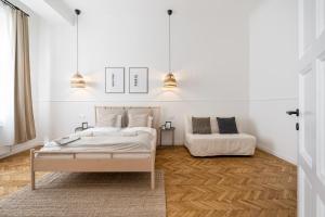 two beds in a room with white walls and wooden floors at Harmony House Apartment in Budapest