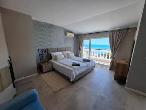 a bedroom with a bed with a view of the ocean at Marina Elegance Apartments in Balchik