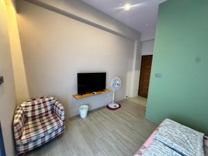 Zimmer mit einem TV, einem Sofa und einem Stuhl in der Unterkunft 漾漾漫旅Young B&B in Fang-liao + 19 Fotos