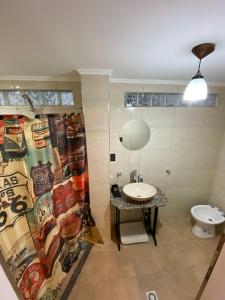 a bathroom with a sink and a shower curtain at Altos 679inn in Comodoro Rivadavia