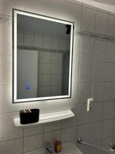a bathroom with a mirror and a sink with a toothbrush at Zentrales Apartment mit Netflix, Kaffee & Parkplätzen in Paderborn +5 photos