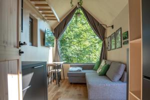 a living room with a couch and a large window at Termalna Osada in Brenna