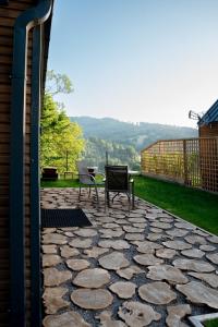 two chairs and a table on a stone patio at Termalna Osada in Brenna