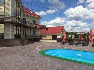 a resort with a swimming pool in front of a building at Hotel Oktan in Kryve Ozero
