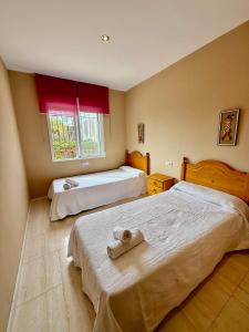 a bedroom with two beds with a towel on the floor at Apartamento Torreblanca III Ref 063 in Torrenostra