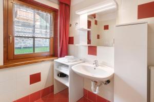une salle de bain avec un lavabo et une fenêtre dans l'établissement Loredana - Al Bait Da Santin, à Livigno