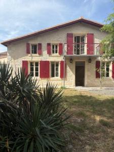ein altes Haus mit roten Fensterläden in der Unterkunft La marmotte in Le Vanneau