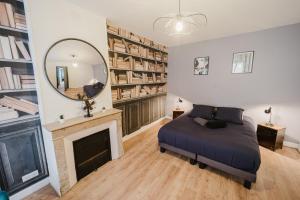 a bedroom with a bed and a mirror and a fireplace at L'historique - Au Cœur de Verdun in Verdun +17 photos